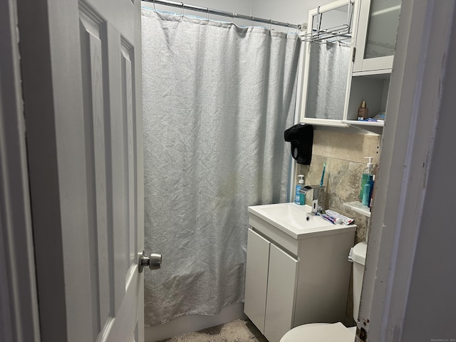 full bathroom featuring toilet, curtained shower, tasteful backsplash, and vanity