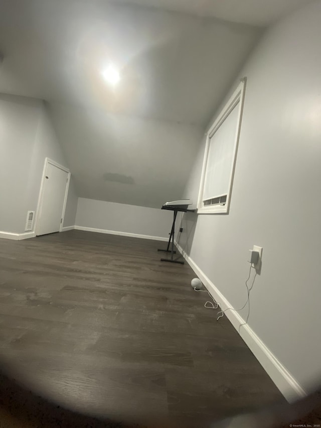 bonus room with baseboards, vaulted ceiling, visible vents, and dark wood finished floors