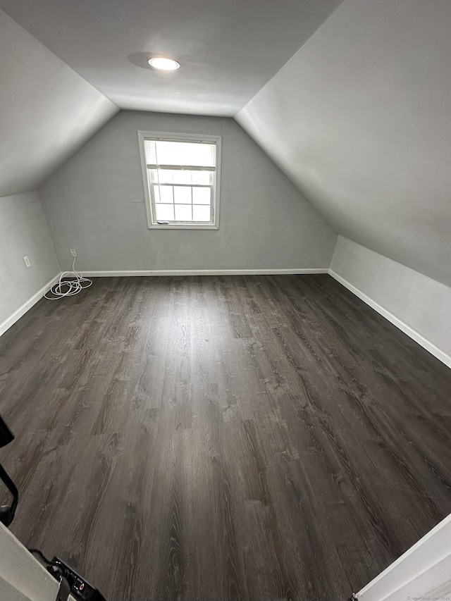 bonus room with lofted ceiling, baseboards, and dark wood-style flooring