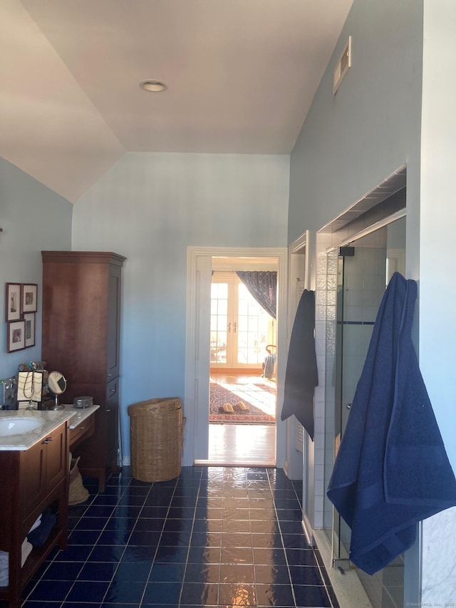 bathroom featuring lofted ceiling, french doors, vanity, and tile patterned floors