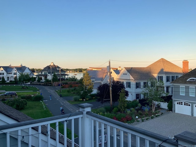 balcony at dusk featuring a residential view