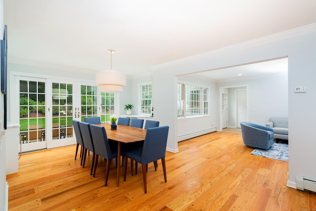 dining room with ornamental molding, a healthy amount of sunlight, a baseboard radiator, and light wood-style floors