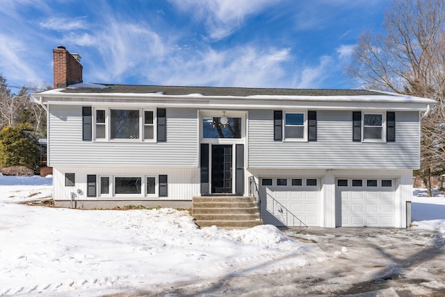 bi-level home with an attached garage and a chimney