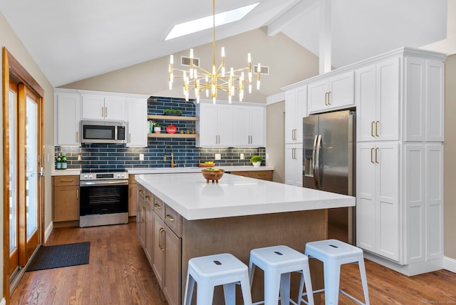 kitchen featuring a chandelier, stainless steel appliances, light countertops, and wood finished floors