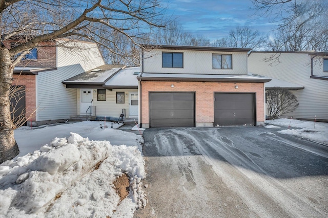 view of front facade featuring driveway, brick siding, and an attached garage