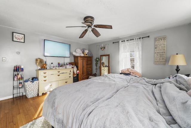 bedroom with ceiling fan and dark wood finished floors