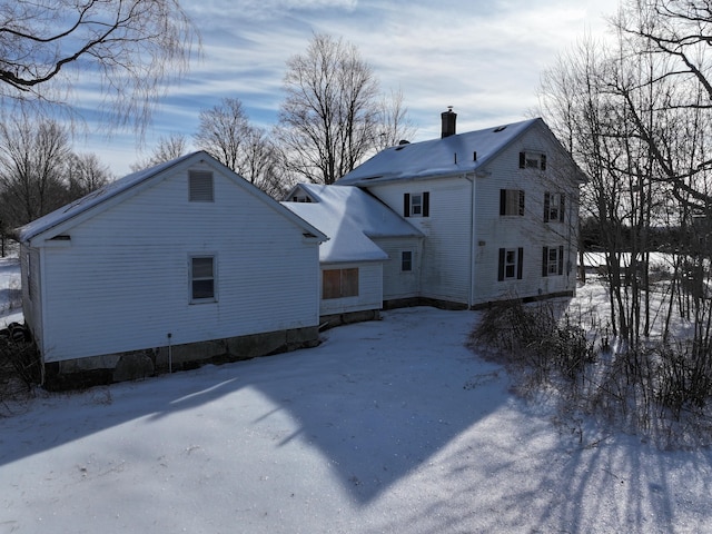 snow covered property featuring a chimney