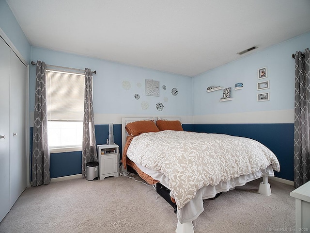 bedroom featuring carpet floors, a closet, visible vents, and baseboards