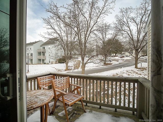 view of snow covered back of property