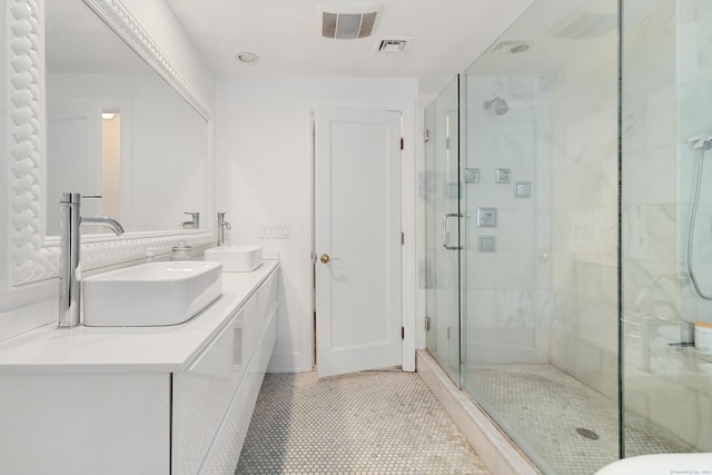 bathroom with tile patterned flooring, a shower stall, visible vents, and a sink