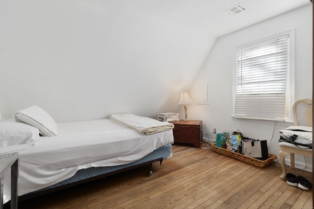 bedroom featuring visible vents, lofted ceiling, and hardwood / wood-style flooring