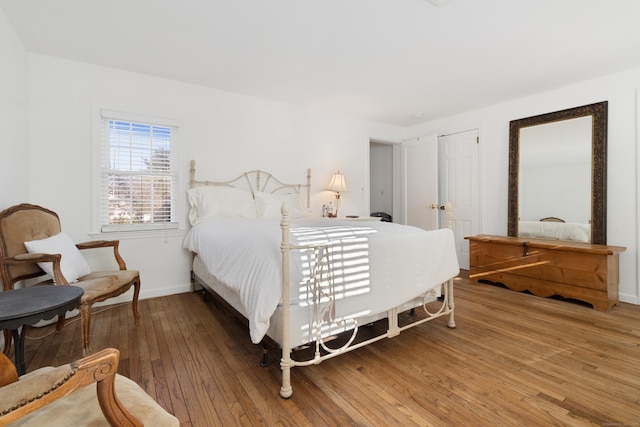 bedroom featuring baseboards and light wood finished floors