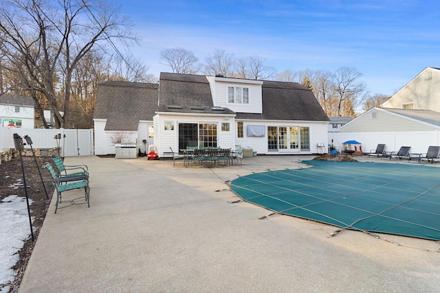 rear view of house with a fenced in pool, a patio, a shingled roof, a gate, and fence