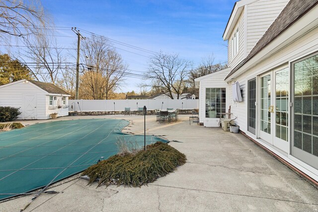 view of pool featuring a fenced in pool, a storage unit, a patio area, a fenced backyard, and an outdoor structure