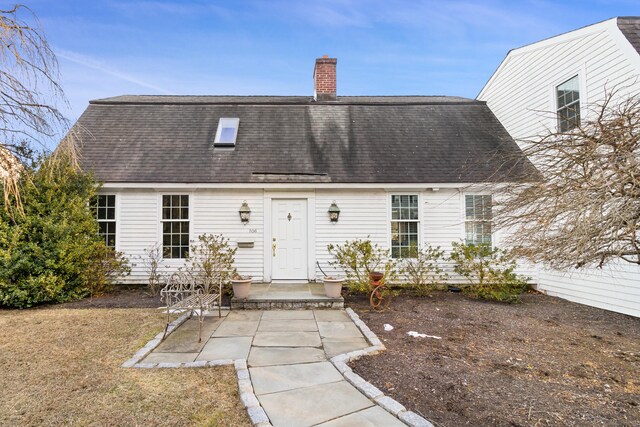 back of house featuring a shingled roof, a chimney, and a patio area