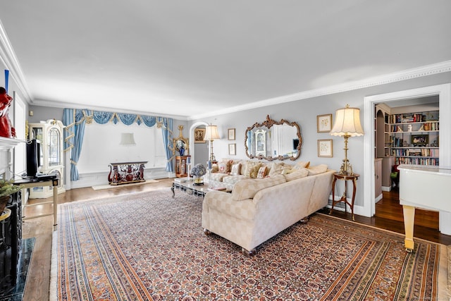 living room featuring baseboards, ornamental molding, arched walkways, and dark wood-style flooring