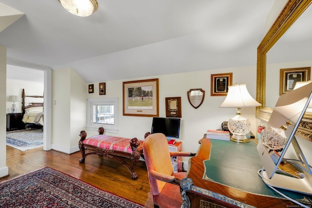 home office featuring lofted ceiling, baseboards, and wood finished floors