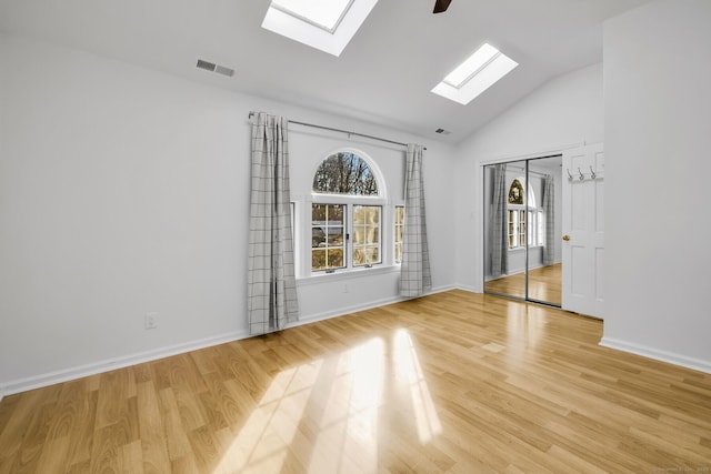 unfurnished room with lofted ceiling, light wood-style floors, baseboards, and visible vents