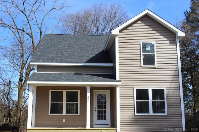 traditional-style house with a porch and a shingled roof