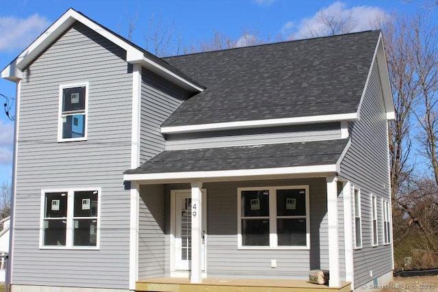 traditional-style home with covered porch and roof with shingles