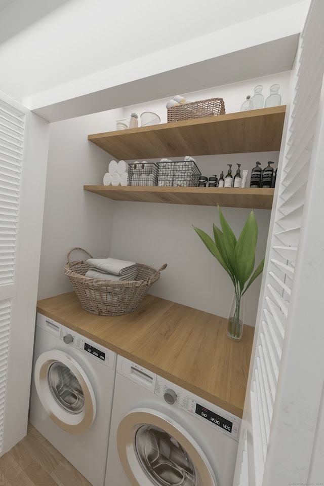 laundry area featuring washing machine and clothes dryer, light wood-style flooring, and laundry area
