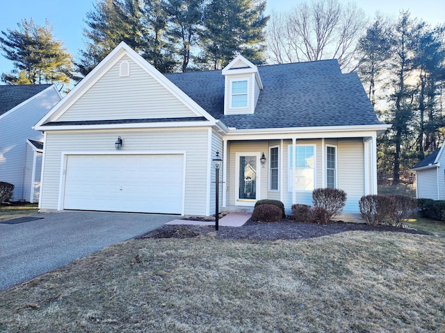 view of front of property featuring a garage, roof with shingles, driveway, and a front lawn