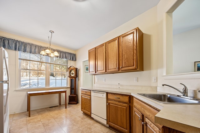 kitchen featuring a sink, an inviting chandelier, brown cabinets, and dishwasher