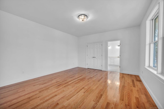 spare room featuring light wood-type flooring and baseboards