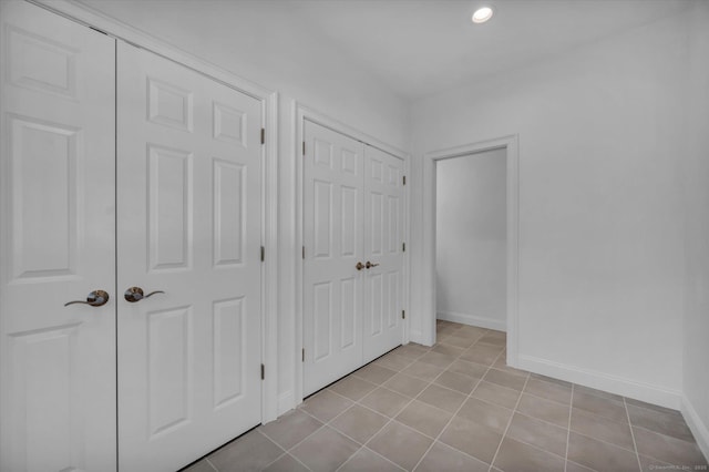 unfurnished bedroom featuring recessed lighting, baseboards, and light tile patterned floors