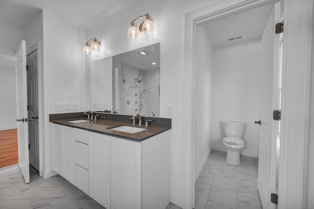 full bath featuring toilet, marble finish floor, baseboards, and a sink