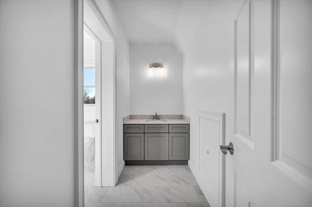 bathroom with toilet, marble finish floor, and vanity