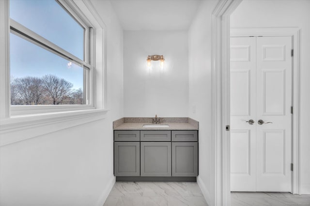 bathroom featuring marble finish floor, baseboards, a closet, and vanity