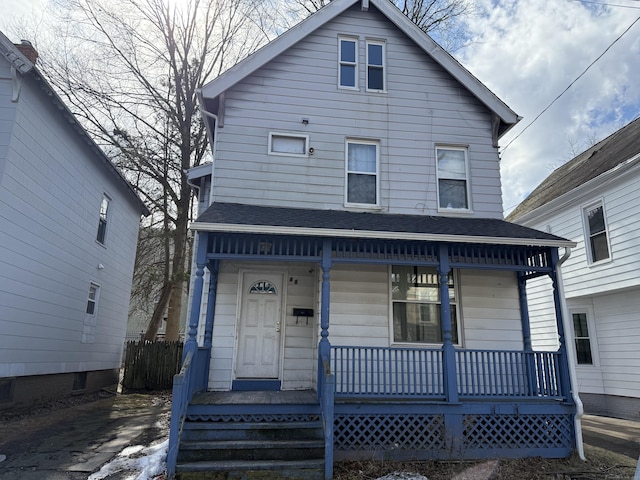 view of front of property featuring covered porch and a shingled roof