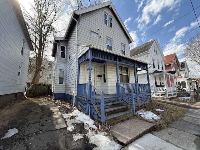 view of front of home with a porch and fence