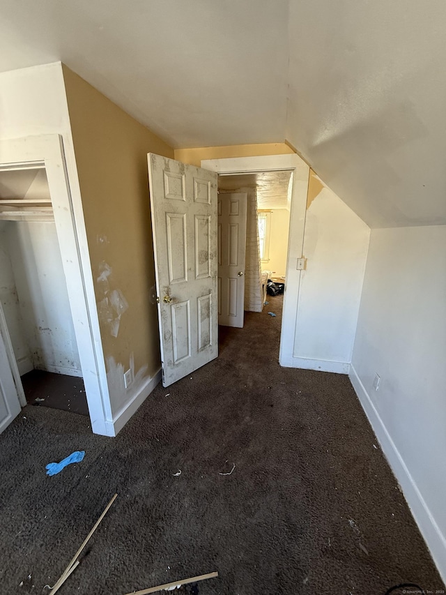 unfurnished bedroom with vaulted ceiling, carpet, and baseboards