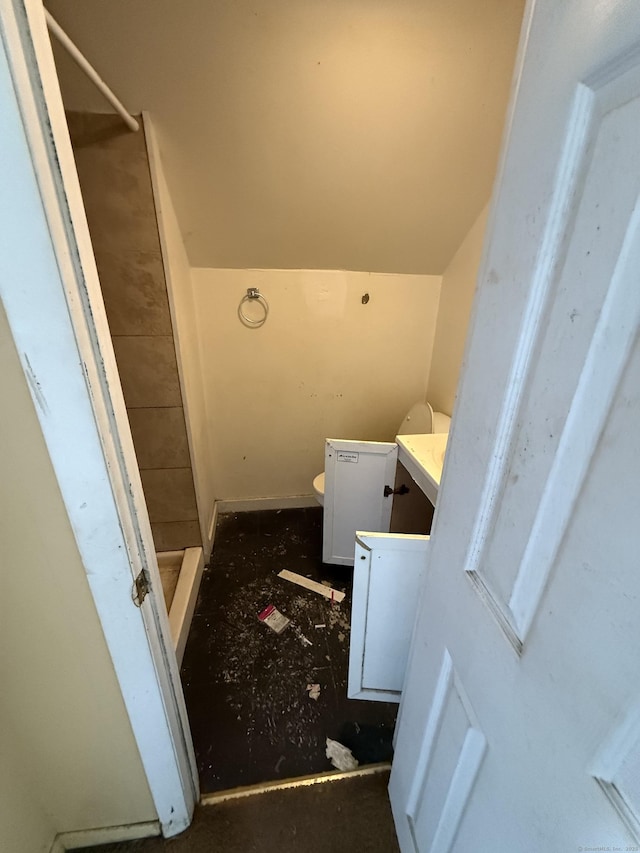 full bathroom featuring vanity, lofted ceiling, toilet, and a stall shower