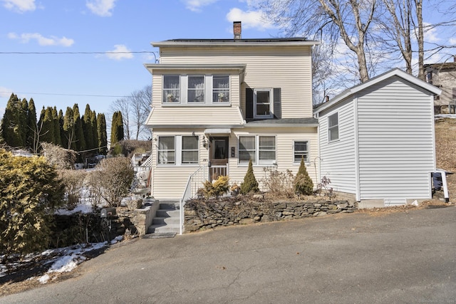 view of front of house featuring roof mounted solar panels and a chimney