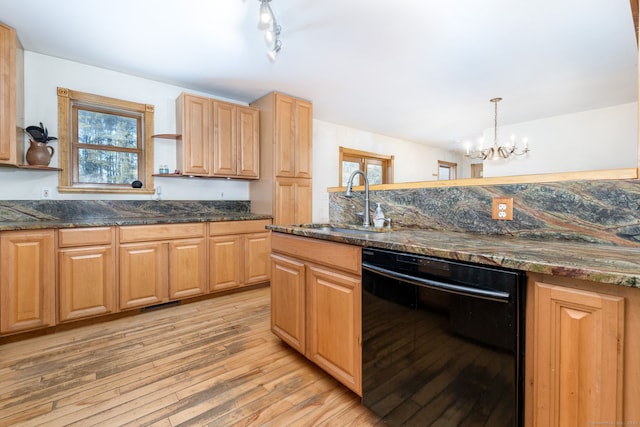 kitchen with black dishwasher, dark stone counters, light wood-style flooring, open shelves, and a sink