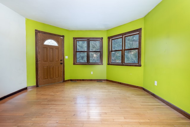 foyer entrance featuring light wood-style flooring and baseboards