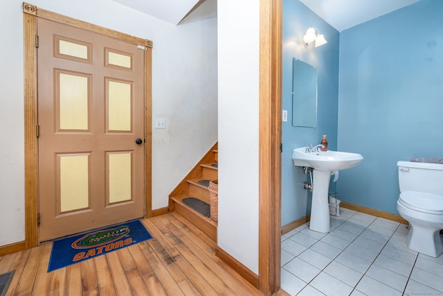 bathroom with baseboards, toilet, and wood finished floors