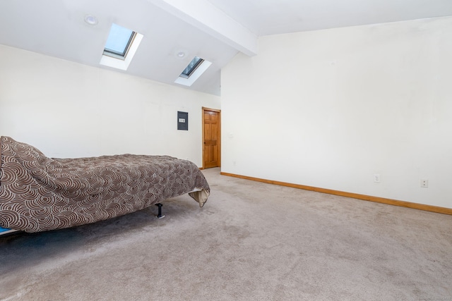 bedroom featuring carpet floors, vaulted ceiling with skylight, and baseboards