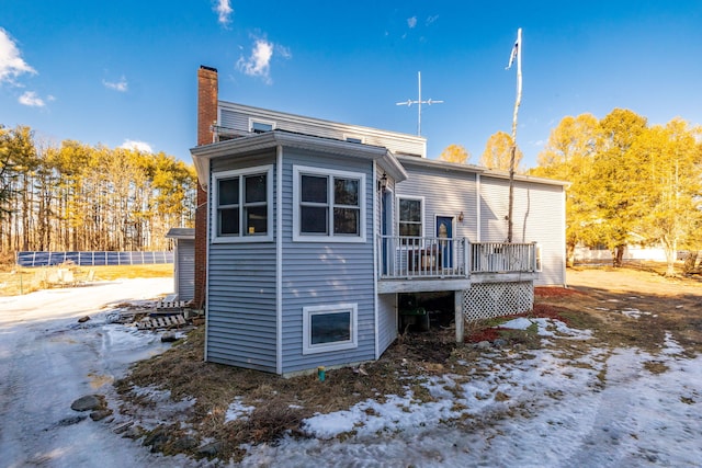 rear view of property with a deck and a chimney