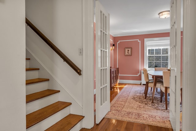 staircase featuring wood finished floors and baseboards