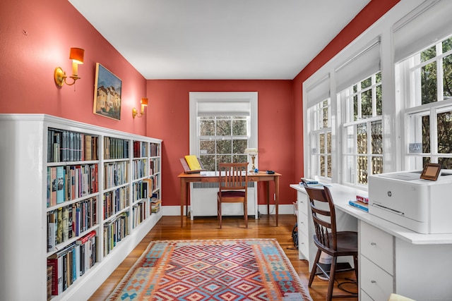 office with a wealth of natural light, radiator heating unit, baseboards, and wood finished floors