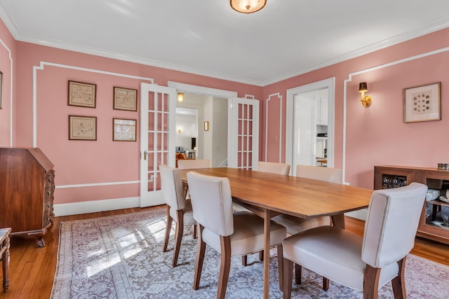 dining room featuring french doors, wood finished floors, and ornamental molding