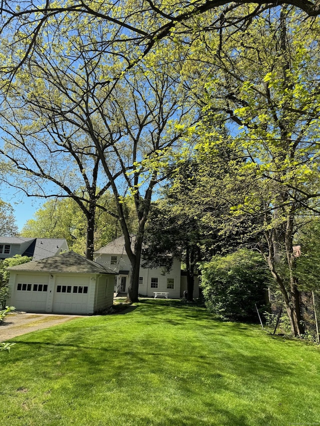 view of front of home featuring a front yard, an attached garage, and dirt driveway