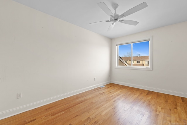 empty room featuring light wood-type flooring, visible vents, baseboards, and a ceiling fan