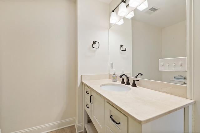 bathroom featuring baseboards, visible vents, and vanity