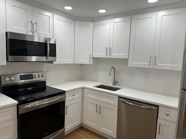 kitchen featuring a sink, appliances with stainless steel finishes, and white cabinets