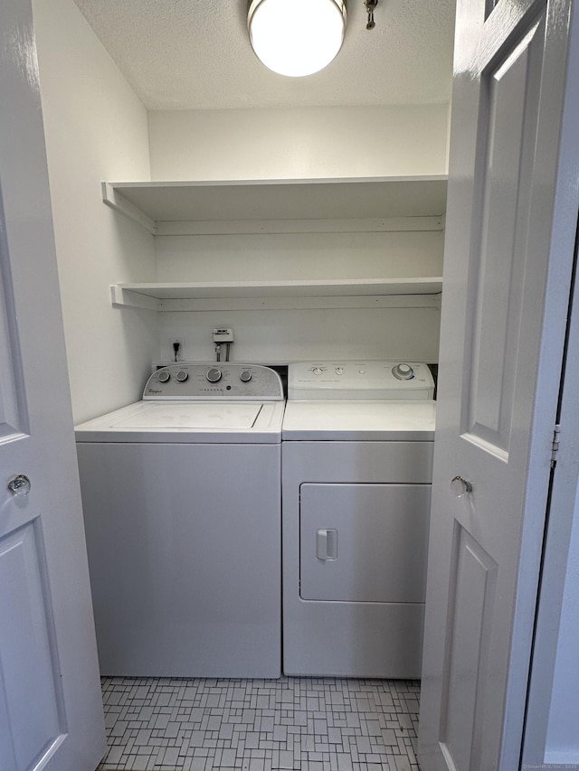 laundry area featuring washer and dryer, laundry area, and a textured ceiling